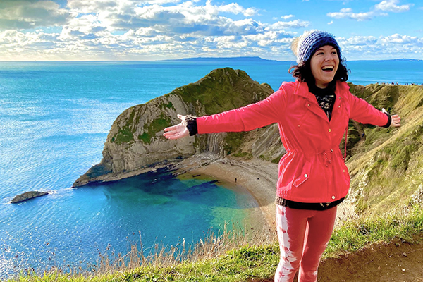 A student with their arms out wide taking in an expansive vista.