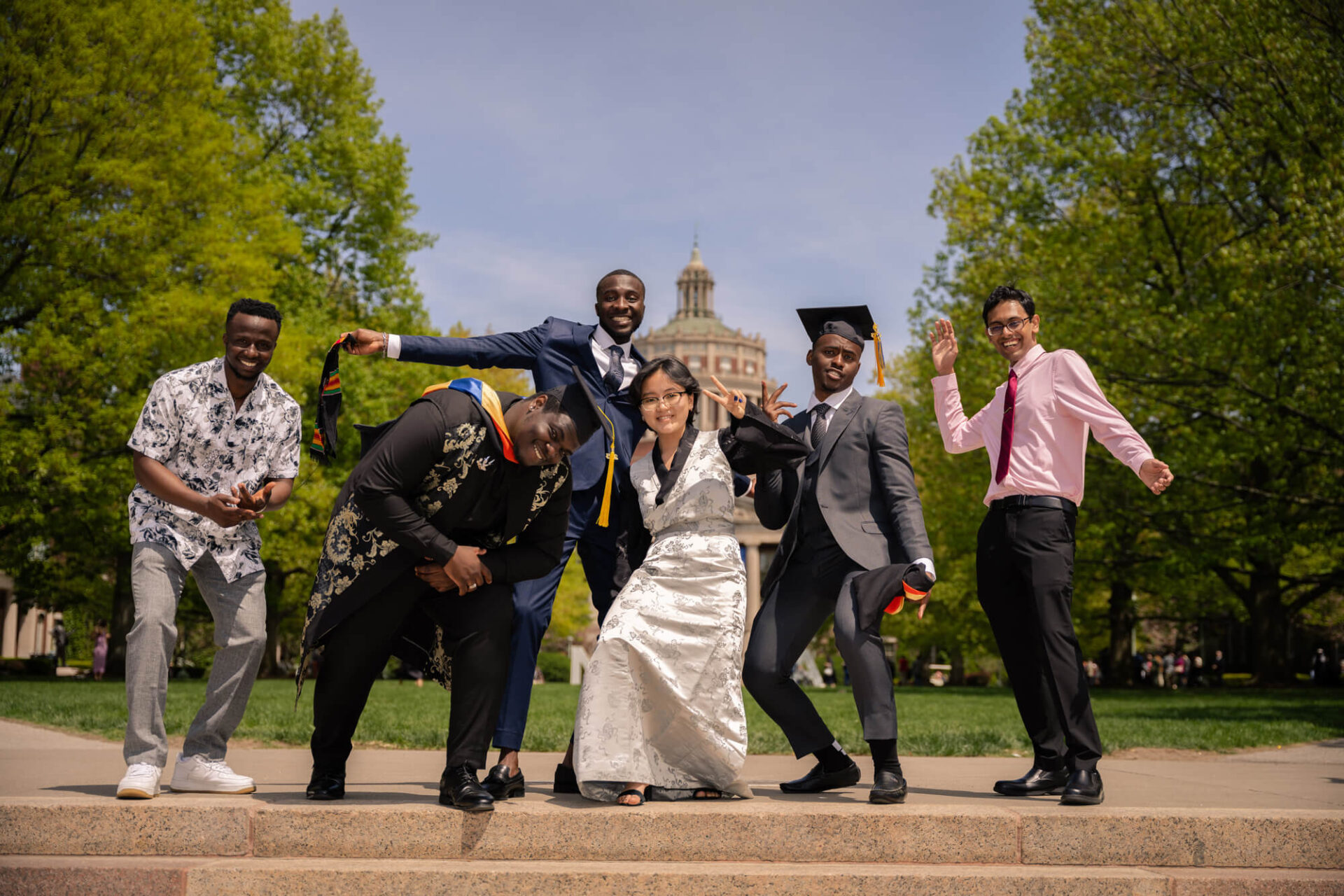 Graduating International Students posing in front of Rush Rhess