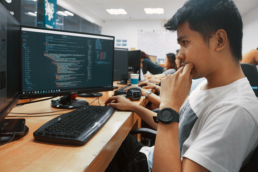 A person contemplating a computer screen of code.