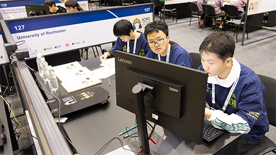 Three students sitting at a computer.