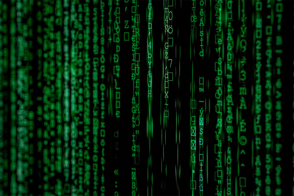 A black computer screen with vertical lines of green code.